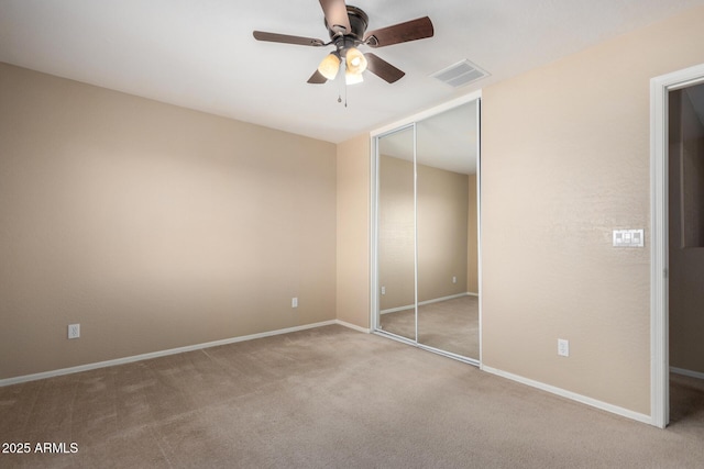 unfurnished bedroom featuring carpet floors, a ceiling fan, visible vents, baseboards, and a closet