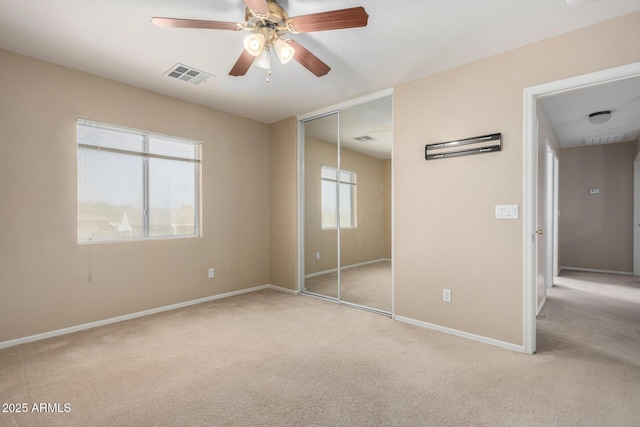 unfurnished bedroom with multiple windows, visible vents, and carpet flooring