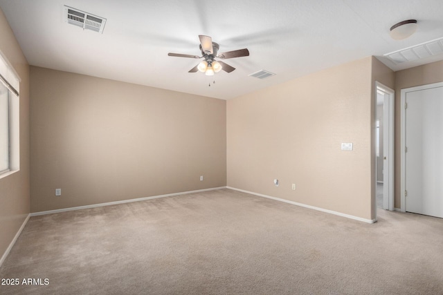 carpeted empty room featuring ceiling fan, visible vents, and baseboards