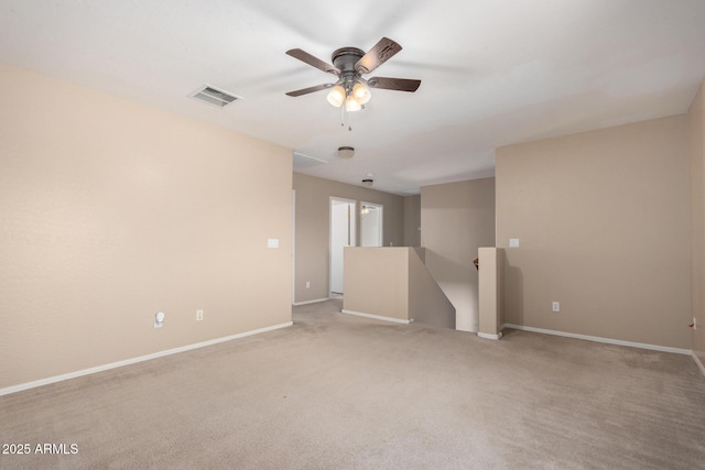 carpeted empty room featuring visible vents, ceiling fan, and baseboards