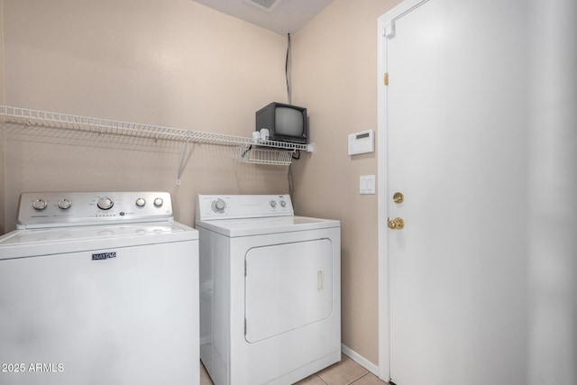 washroom featuring laundry area, light tile patterned floors, baseboards, visible vents, and separate washer and dryer