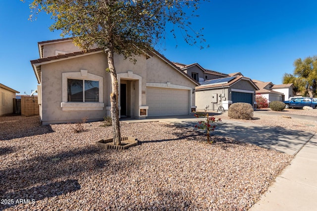 view of front facade featuring a garage, driveway, fence, and stucco siding