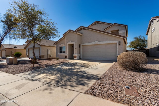 view of front facade featuring driveway, an attached garage, a tiled roof, and stucco siding