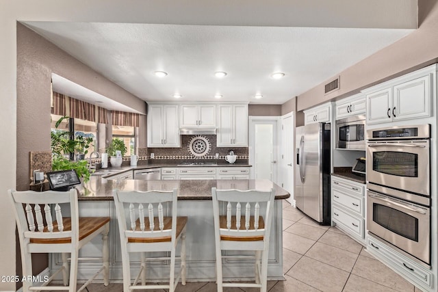 3203 E Ellis St, Mesa, AZ 85213 - kitchen featuring visible vents, appliances with stainless steel finishes, a sink, white cabinets, and a peninsula