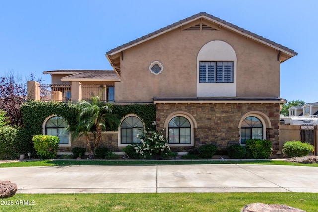 3203 E Ellis St, Mesa, AZ 85213 - mediterranean / spanish-style house with fence, a balcony, stone siding, and stucco siding
