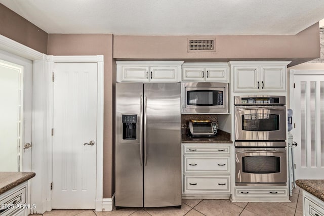 3203 E Ellis St, Mesa, AZ 85213 - kitchen with visible vents, appliances with stainless steel finishes, a toaster, white cabinets, and light tile patterned flooring