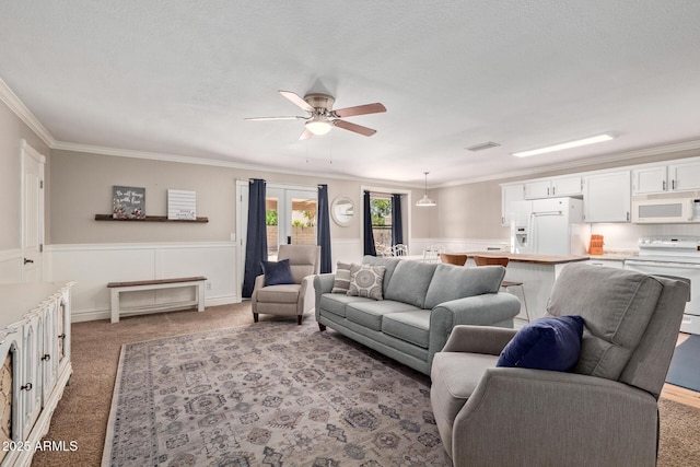 3203 E Ellis St, Mesa, AZ 85213 - carpeted living area with wainscoting, ornamental molding, a ceiling fan, and visible vents