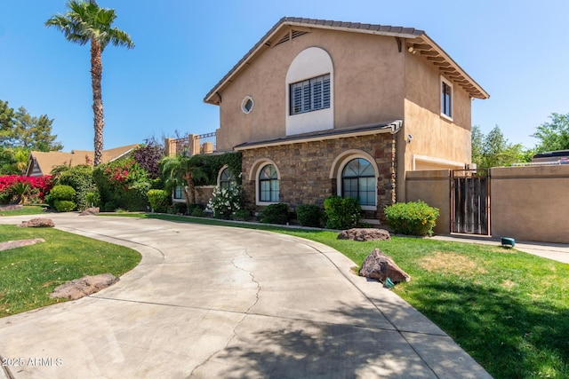 3203 E Ellis St, Mesa, AZ 85213 - mediterranean / spanish home with a front yard, stone siding, curved driveway, stucco siding, and a gate