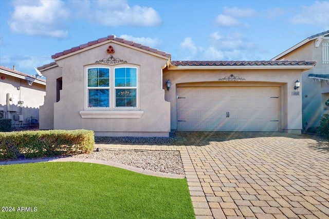 mediterranean / spanish house featuring a front lawn and a garage