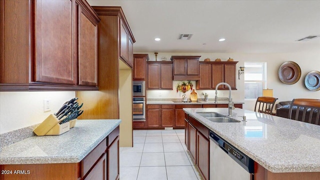 kitchen featuring light stone counters, stainless steel appliances, a kitchen island with sink, sink, and light tile patterned floors