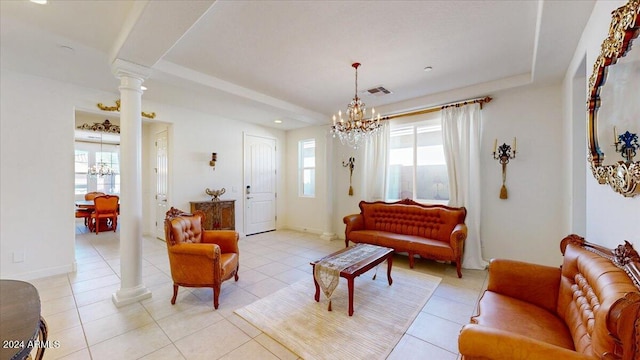 tiled living room with decorative columns and an inviting chandelier