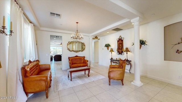 living area featuring ceiling fan with notable chandelier, a raised ceiling, ornate columns, and light tile patterned floors