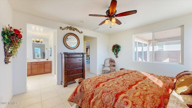 tiled bedroom featuring ensuite bath and ceiling fan