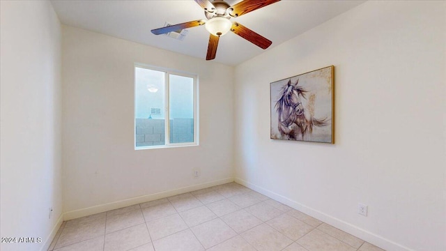 tiled empty room featuring ceiling fan