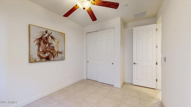 unfurnished bedroom featuring ceiling fan and a closet