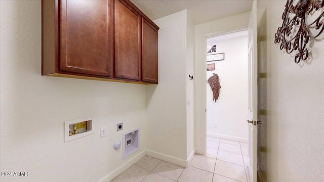 clothes washing area with electric dryer hookup, hookup for a washing machine, light tile patterned floors, and cabinets