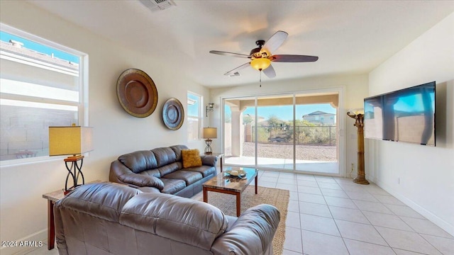 tiled living room featuring ceiling fan and plenty of natural light