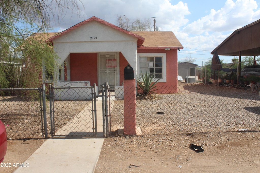 2121 W Tonto St, Phoenix, AZ 85009 - view of front of home with a gate, stucco siding, and central AC unit