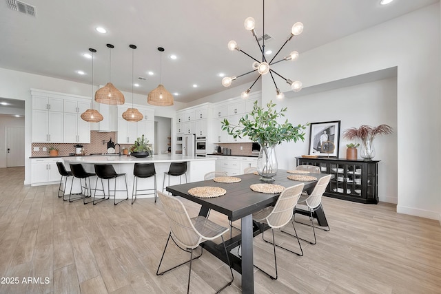 dining area featuring light wood-type flooring, an inviting chandelier, visible vents, and recessed lighting