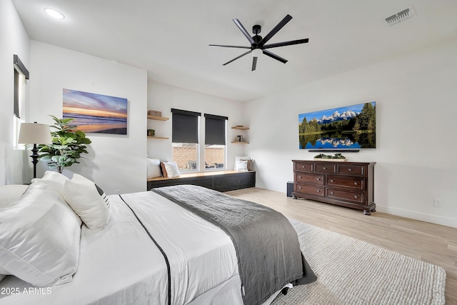 bedroom featuring a ceiling fan, wood finished floors, visible vents, and baseboards