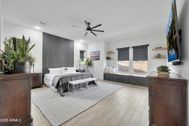 bedroom featuring ceiling fan, wood finished floors, visible vents, and baseboards