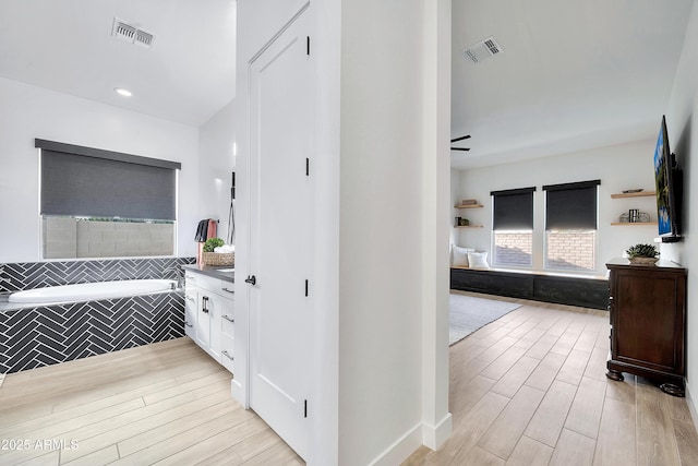 full bath with a garden tub, vanity, visible vents, and wood tiled floor