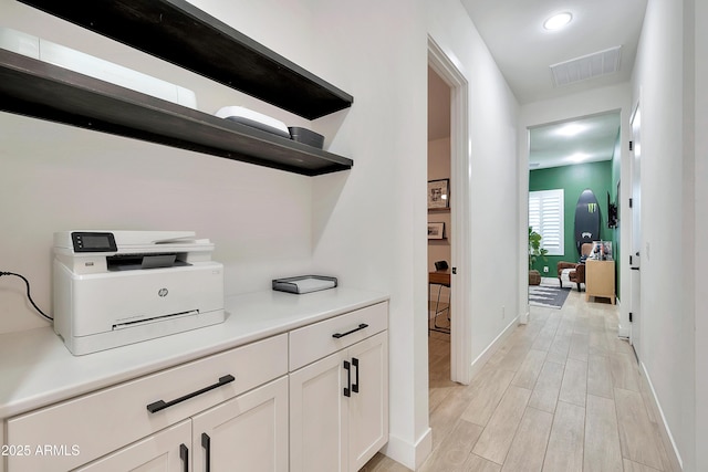 hall featuring light wood-type flooring, baseboards, visible vents, and recessed lighting