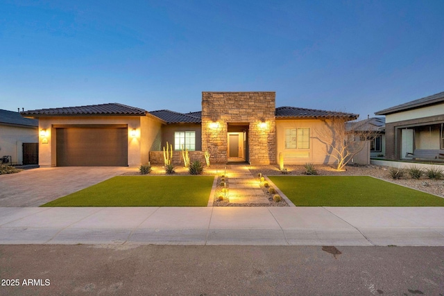 view of front of property with stone siding, a tiled roof, decorative driveway, a front lawn, and stucco siding