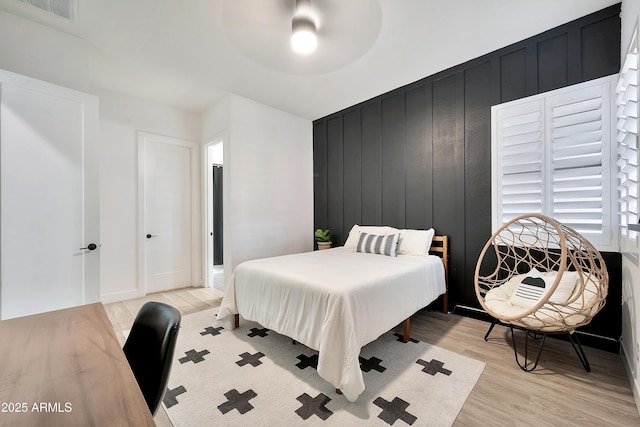 bedroom featuring light wood finished floors, visible vents, and a ceiling fan