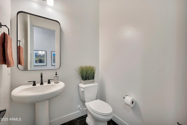 bathroom featuring toilet, baseboards, and tile patterned floors