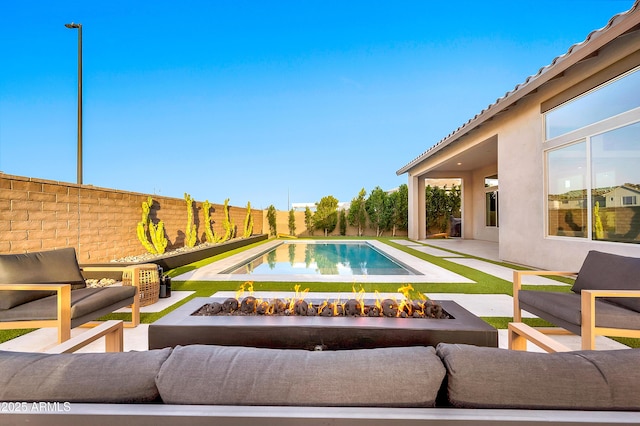 view of swimming pool with an outdoor living space with a fire pit, a fenced backyard, a fenced in pool, and a patio