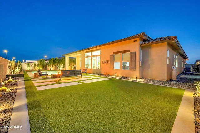 back of house with a yard, stucco siding, an outdoor hangout area, a patio area, and a fenced backyard