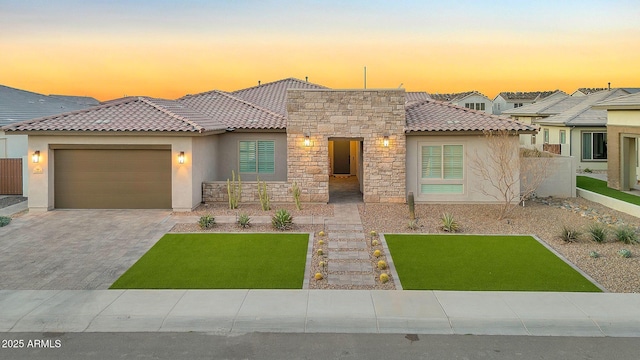 view of front of property with a tile roof, an attached garage, and stucco siding