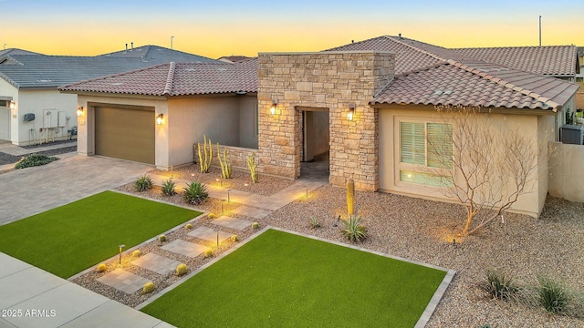 view of front facade featuring stone siding, a tile roof, an attached garage, decorative driveway, and stucco siding