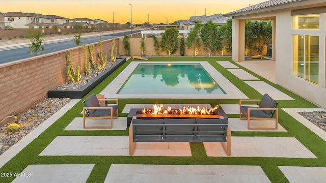 view of pool with a patio area, an outdoor fire pit, a residential view, and a fenced backyard