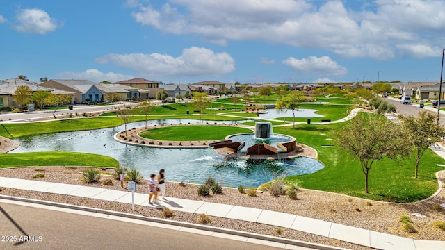 view of community featuring a yard, a water view, and a residential view