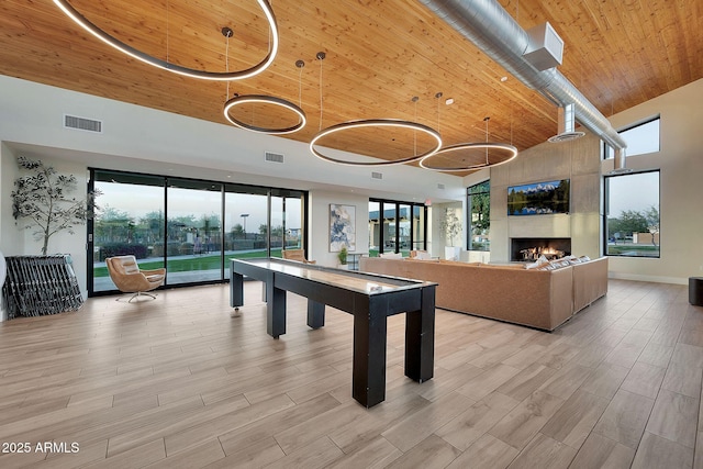 playroom with high vaulted ceiling, wooden ceiling, a fireplace, visible vents, and light wood finished floors