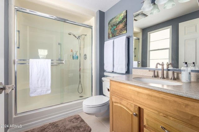 bathroom featuring tile patterned floors, toilet, a shower with door, and vanity