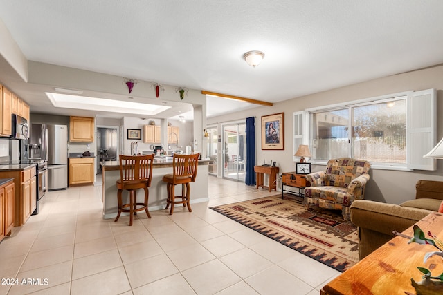 living room with a textured ceiling, light tile patterned floors, and a wealth of natural light