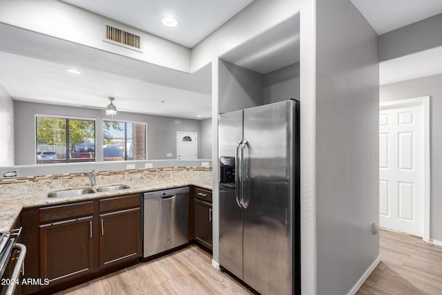 kitchen featuring sink, kitchen peninsula, stainless steel appliances, and light hardwood / wood-style flooring