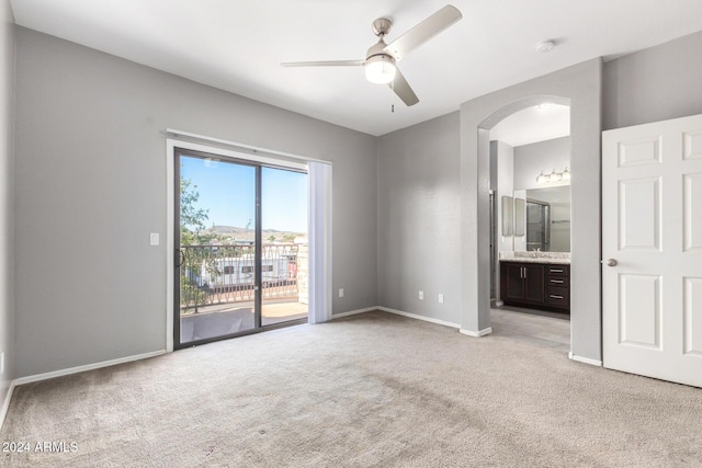 unfurnished bedroom with sink, ceiling fan, access to exterior, connected bathroom, and light colored carpet