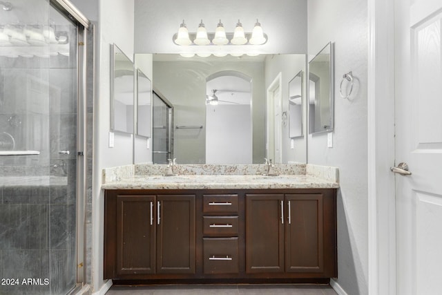 bathroom with vanity, ceiling fan, and a shower with door