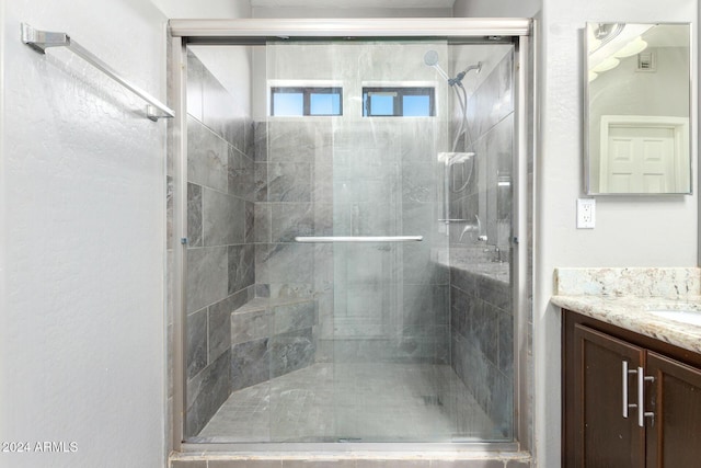 bathroom featuring vanity and a shower with shower door