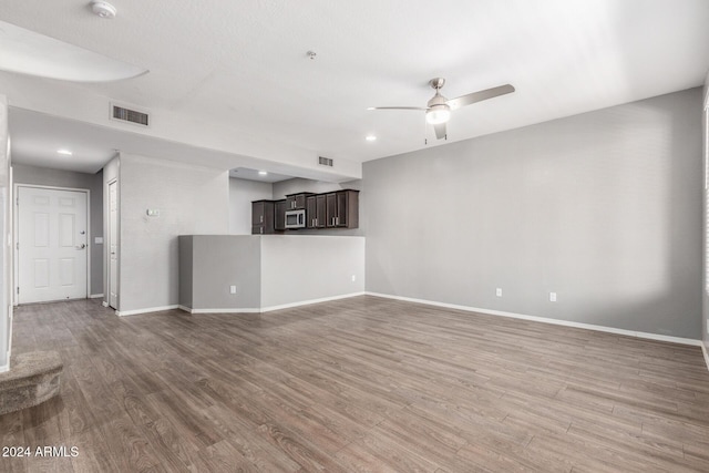 unfurnished living room featuring ceiling fan and hardwood / wood-style flooring