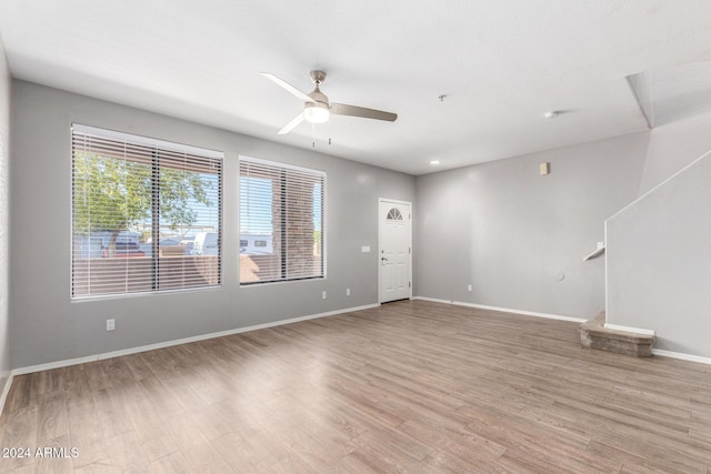 unfurnished living room featuring ceiling fan and light hardwood / wood-style floors