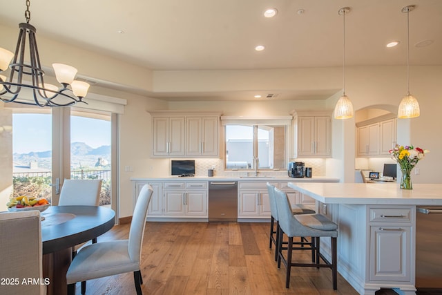 kitchen featuring plenty of natural light, decorative light fixtures, sink, and light hardwood / wood-style flooring