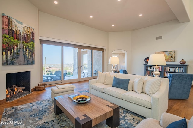 living room featuring hardwood / wood-style flooring, french doors, and a towering ceiling