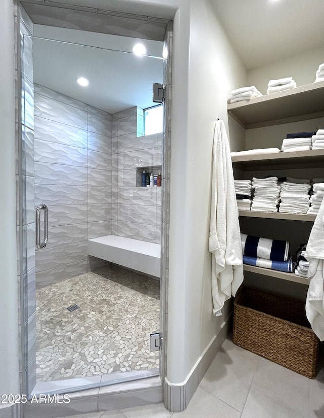 bathroom featuring a shower with shower door and tile patterned floors