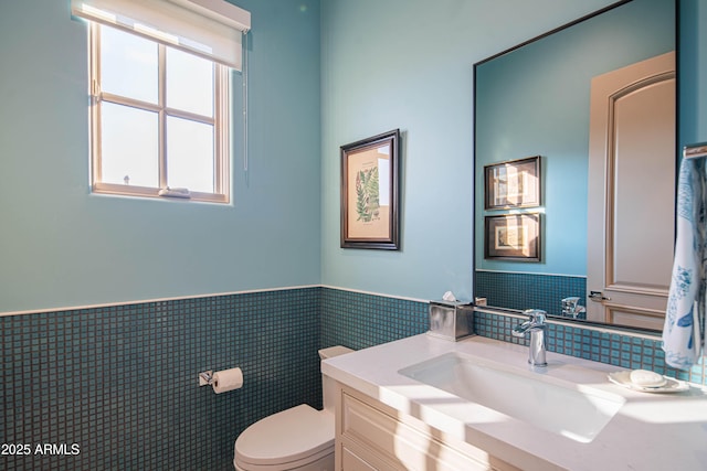 bathroom with vanity, tile walls, and toilet