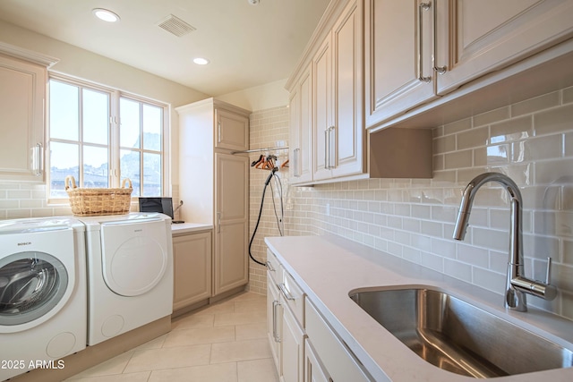 washroom featuring cabinets, light tile patterned flooring, separate washer and dryer, and sink